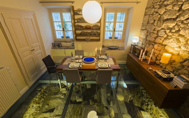 Interior dining setting with ancient ruin display during a Private dinner in an Athenian townhouse by Discover Greek Culture